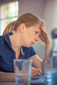 Woman at laptop, glass of water